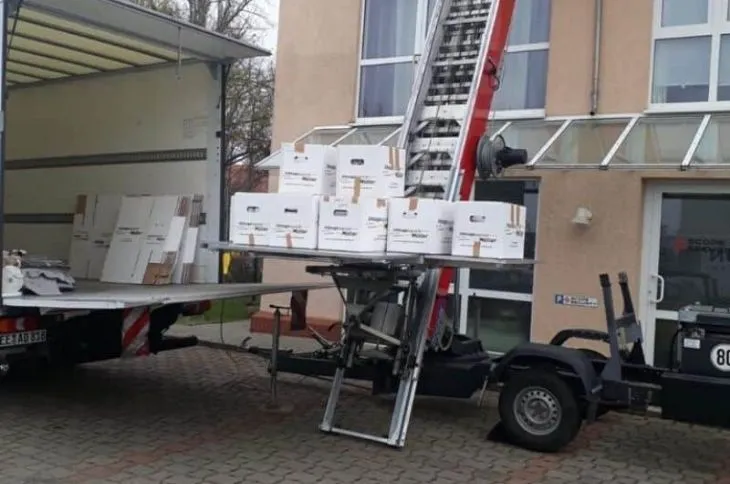 moebellift mit umzugskartons vor mehrfamilienhaus